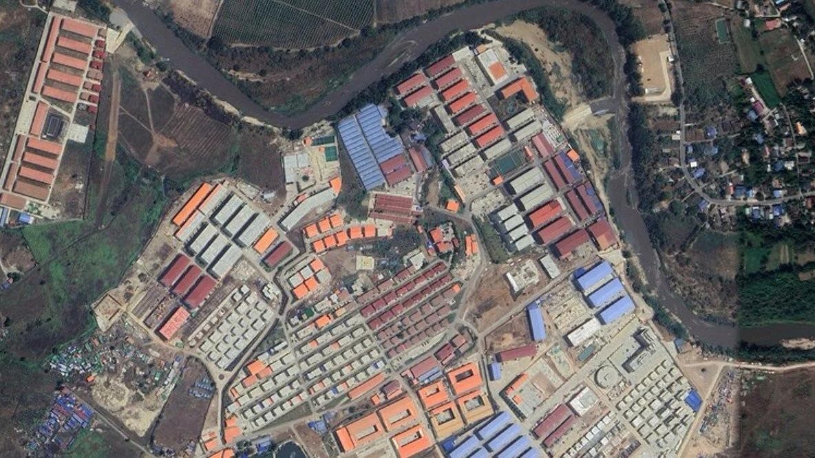 Aerial view of a large compound beside a river